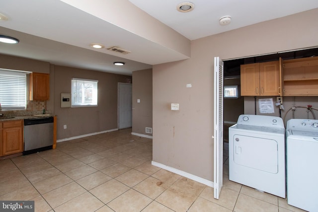 laundry room with visible vents, baseboards, laundry area, light tile patterned flooring, and washing machine and dryer