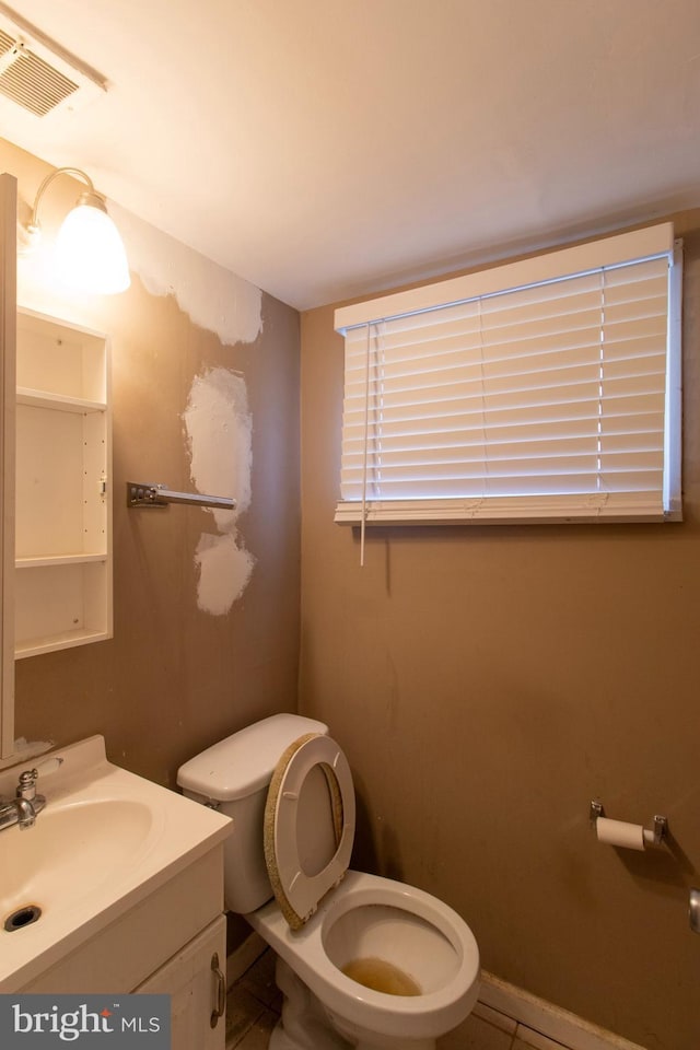 bathroom featuring visible vents, toilet, and vanity