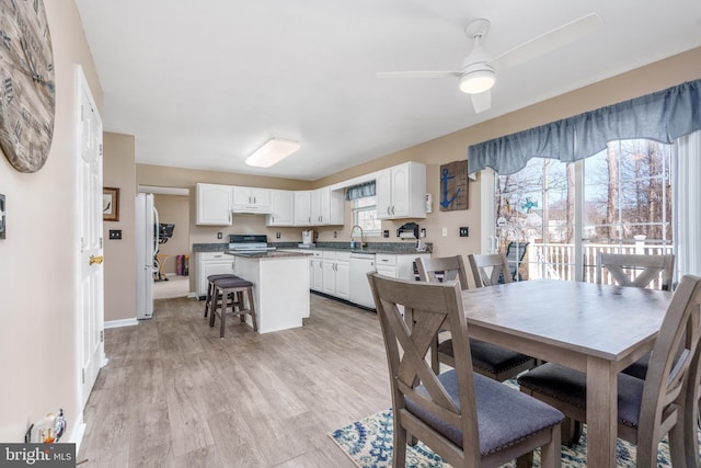 dining area featuring light wood-style floors, ceiling fan, and baseboards