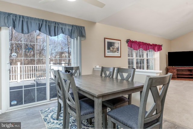 dining space featuring ceiling fan, wood finished floors, and lofted ceiling