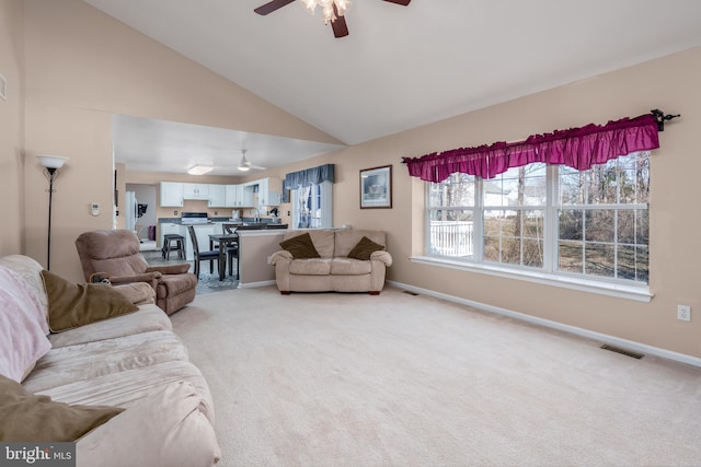 living room featuring light colored carpet, visible vents, a ceiling fan, high vaulted ceiling, and baseboards