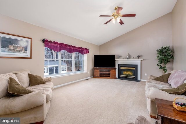 living area with lofted ceiling, light carpet, a fireplace with flush hearth, a ceiling fan, and baseboards