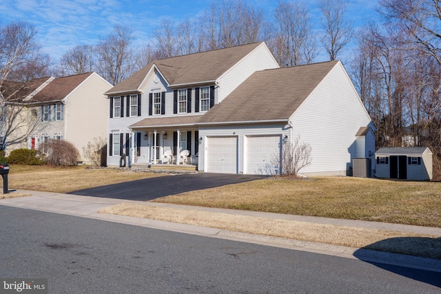 view of front of home with a garage, driveway, a shingled roof, covered porch, and a front yard