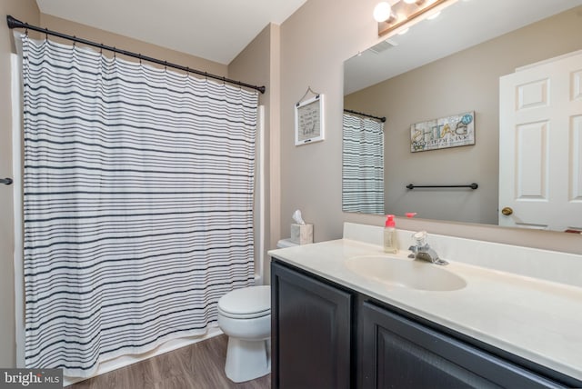 bathroom with toilet, visible vents, wood finished floors, and vanity