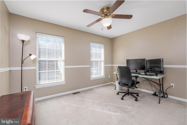 carpeted office space featuring a ceiling fan, visible vents, and baseboards