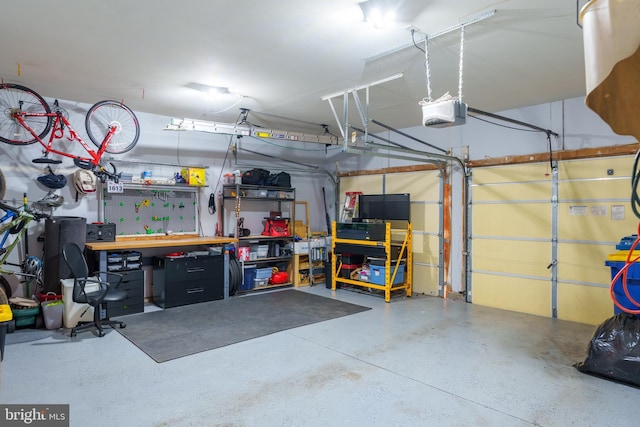 garage with a workshop area and a garage door opener