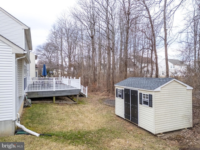 view of yard with an outbuilding, a shed, and a deck