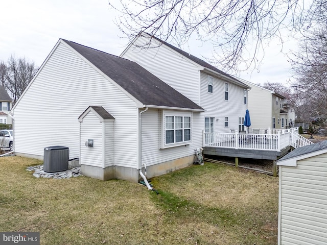 back of house featuring a shingled roof, a deck, cooling unit, and a yard