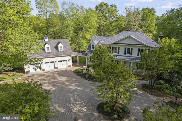 view of front of home with a garage and decorative driveway