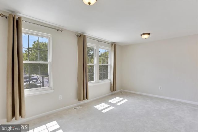 carpeted empty room with visible vents and baseboards