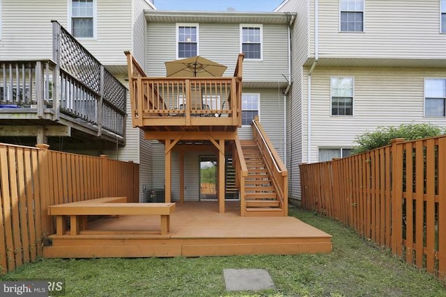 rear view of property with stairway, a fenced backyard, and a wooden deck