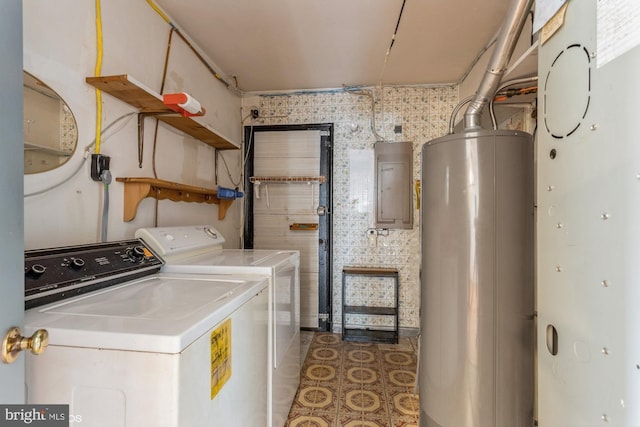 clothes washing area featuring laundry area, electric panel, tile patterned flooring, washing machine and dryer, and gas water heater