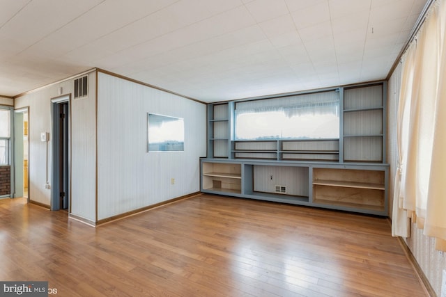 unfurnished living room with a wealth of natural light and hardwood / wood-style floors