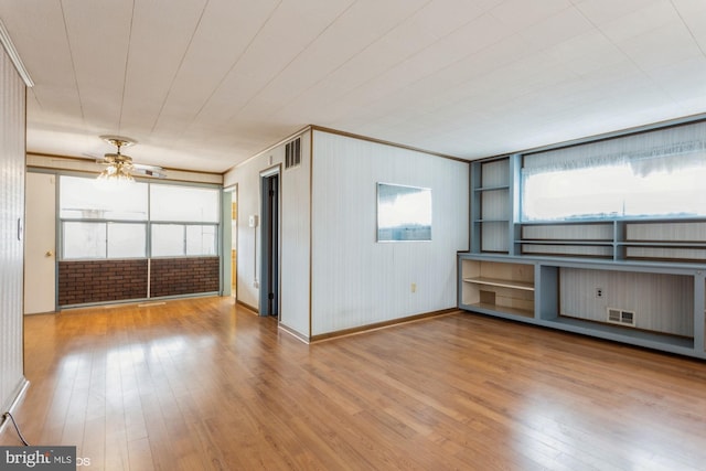 unfurnished living room featuring hardwood / wood-style flooring, baseboards, visible vents, and a ceiling fan