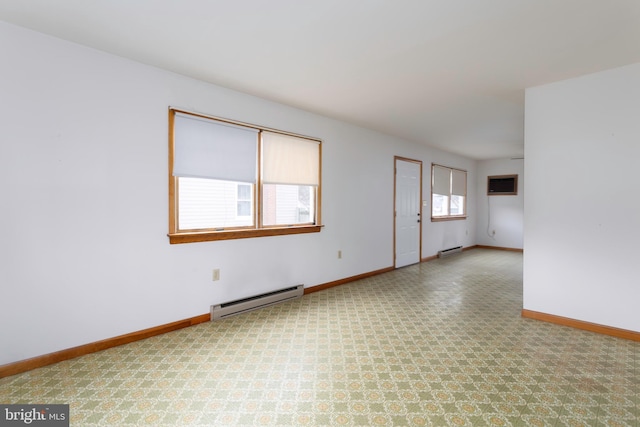 spare room featuring a wall unit AC, baseboards, and a baseboard heating unit