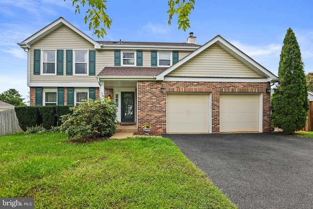 traditional-style house with aphalt driveway, brick siding, a chimney, a garage, and a front lawn