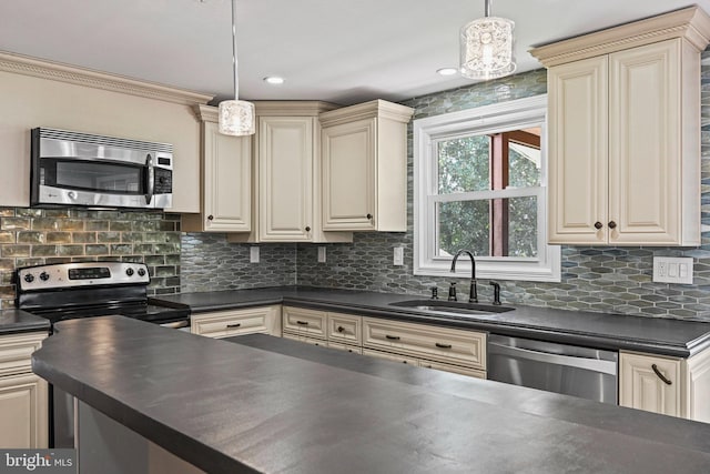 kitchen featuring appliances with stainless steel finishes, cream cabinets, and dark countertops