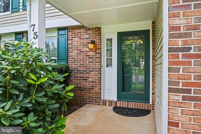 view of exterior entry with brick siding