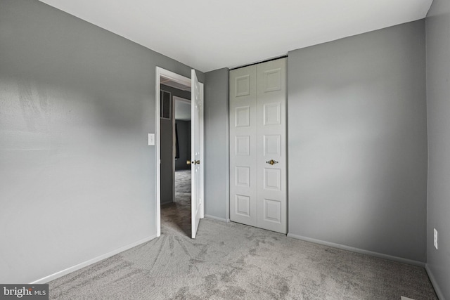 unfurnished bedroom featuring carpet and baseboards