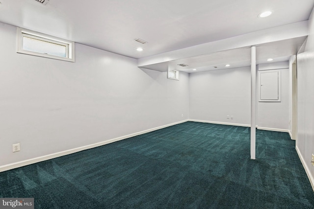 basement featuring baseboards, dark carpet, and recessed lighting