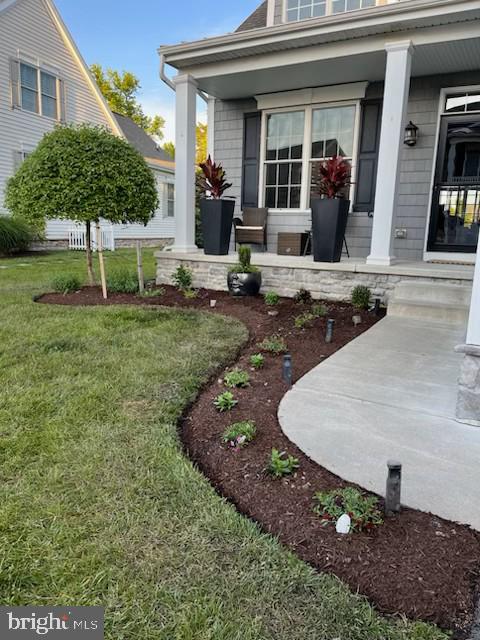 property entrance with covered porch and a yard