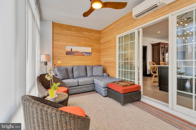 living area featuring ceiling fan, a wall mounted air conditioner, and wooden walls