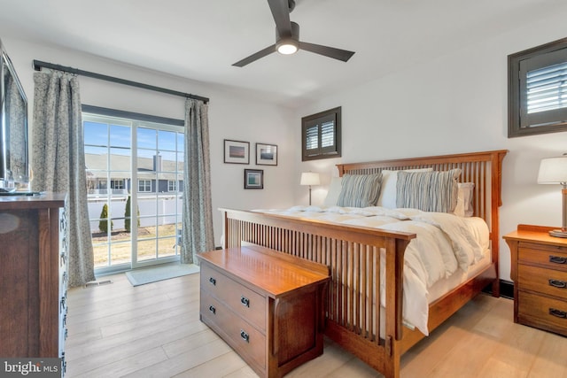 bedroom with light wood-style floors, access to outside, and multiple windows