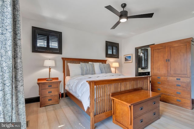 bedroom with baseboards, a ceiling fan, and light wood-style floors