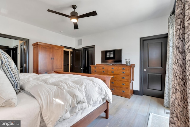 bedroom with light wood-type flooring, ceiling fan, and visible vents