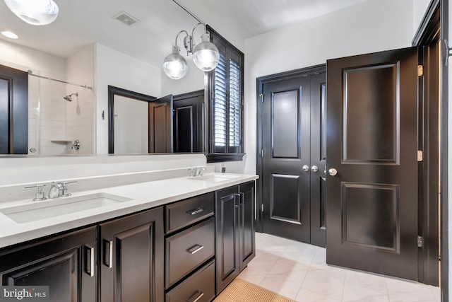 full bath with double vanity, a sink, and visible vents