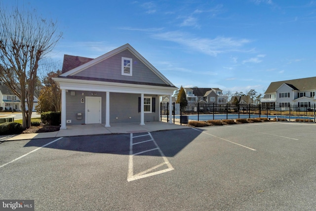 view of property featuring uncovered parking, a residential view, and fence