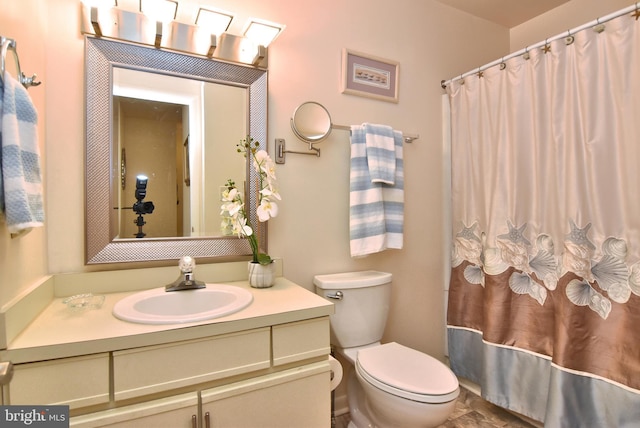 bathroom featuring toilet, a shower with shower curtain, and vanity