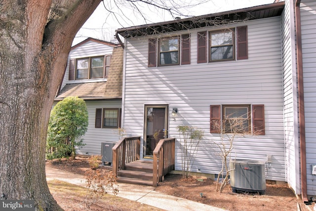 view of front of home featuring a shingled roof and cooling unit