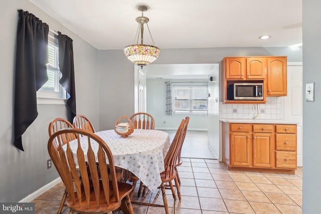 dining space with baseboards and light tile patterned floors