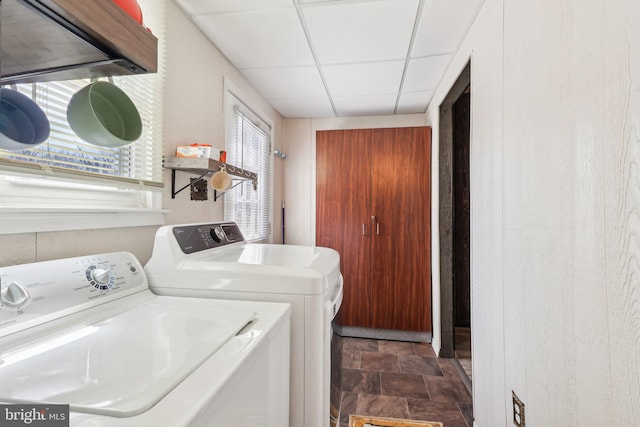 laundry area featuring laundry area, stone finish floor, and washing machine and clothes dryer