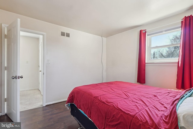 bedroom featuring baseboards, visible vents, and wood finished floors