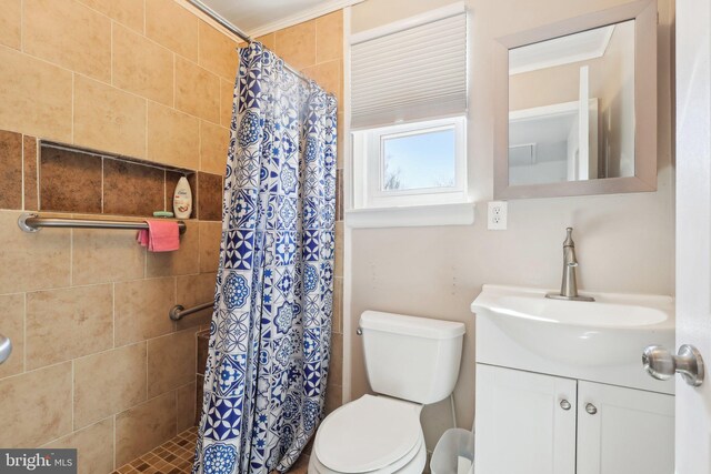 bathroom featuring toilet, ornamental molding, a shower stall, and vanity