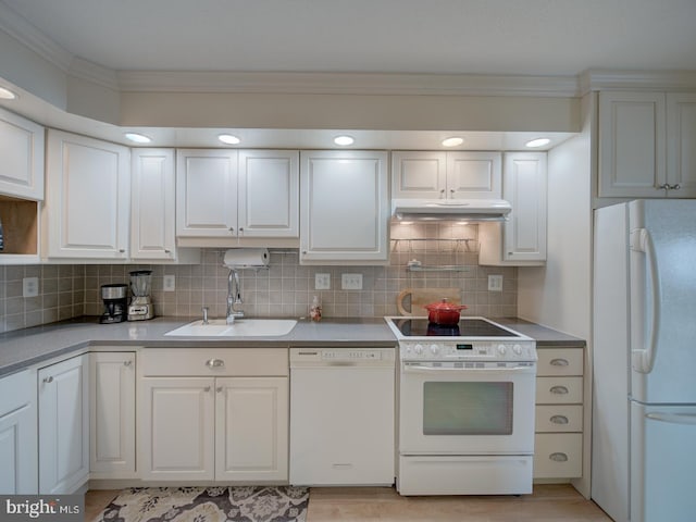 kitchen featuring white appliances, tasteful backsplash, crown molding, under cabinet range hood, and a sink