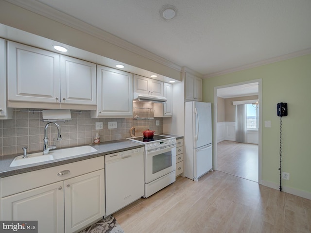 kitchen featuring ornamental molding, white appliances, a sink, and white cabinetry