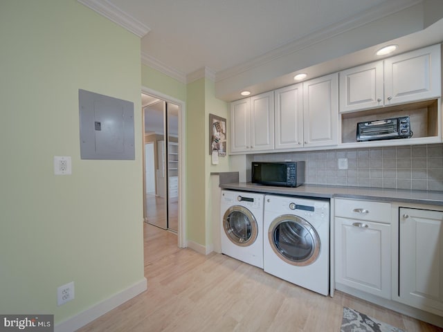 washroom featuring laundry area, electric panel, crown molding, light wood-style floors, and separate washer and dryer