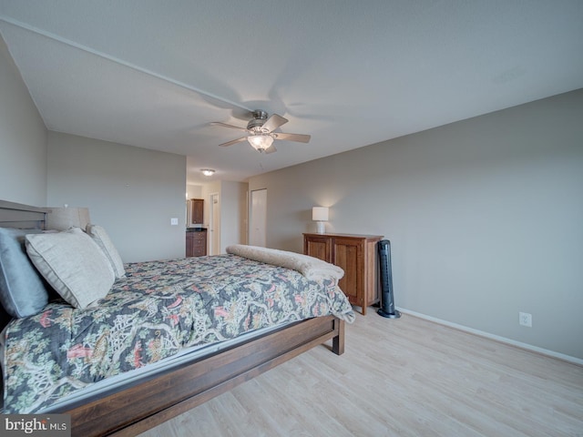 bedroom with a ceiling fan, light wood-style flooring, and baseboards