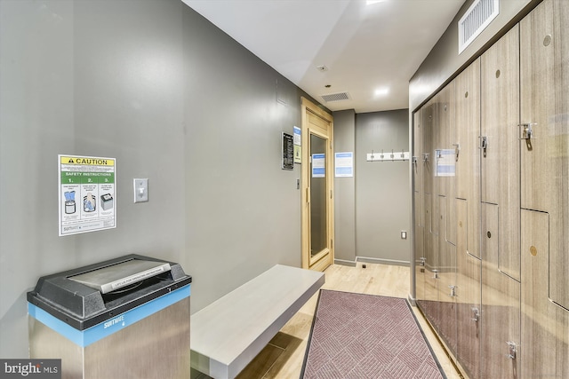 corridor with light wood-style floors and visible vents