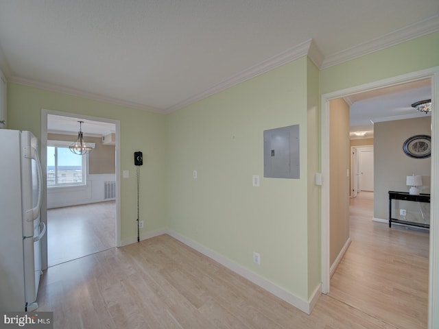 unfurnished room with a chandelier, visible vents, light wood-type flooring, electric panel, and crown molding