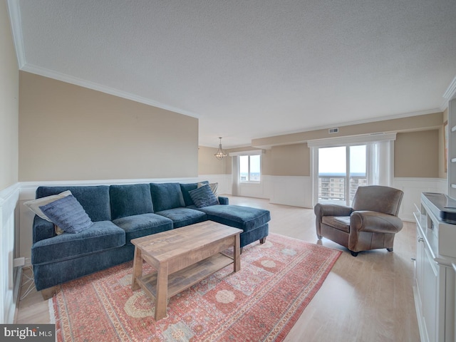 living area featuring light wood finished floors and wainscoting