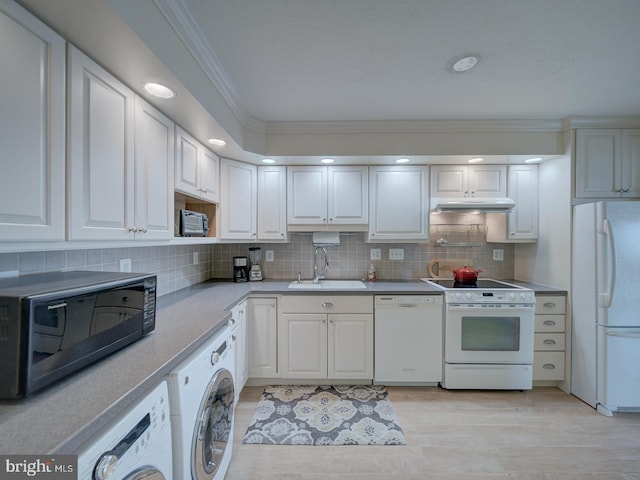 kitchen with white appliances, washer / clothes dryer, a sink, and crown molding