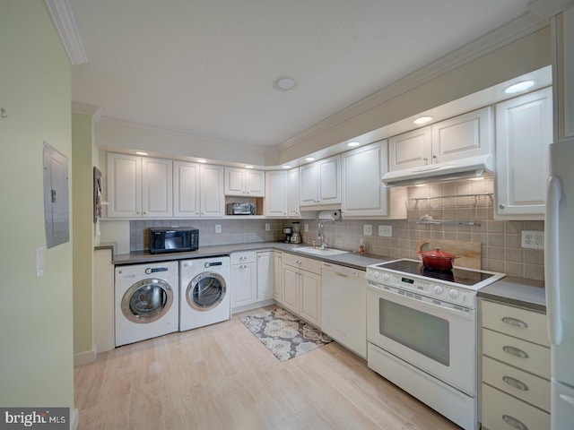 kitchen with ornamental molding, a sink, white appliances, electric panel, and under cabinet range hood