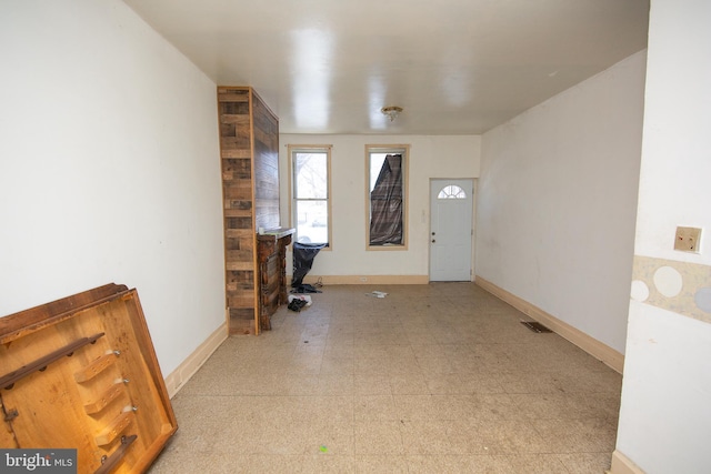 office featuring light floors, visible vents, and baseboards