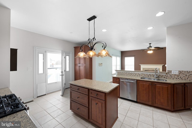 kitchen with light stone counters, a sink, decorative backsplash, dishwasher, and decorative light fixtures