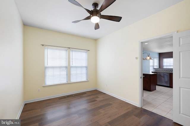 empty room featuring baseboards, ceiling fan, and light wood finished floors