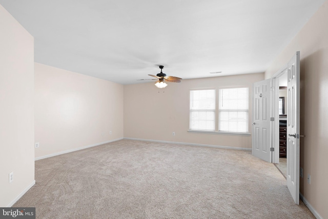 spare room featuring baseboards, ceiling fan, and light colored carpet